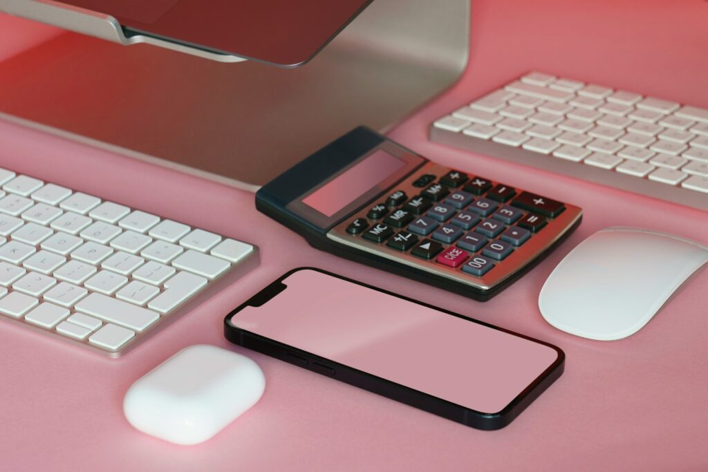 a desk with a keyboard, mouse, and cell phone